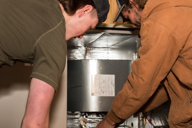 Diagnosing an HVAC unit at at Moore's A/C & Heating Inc. 
